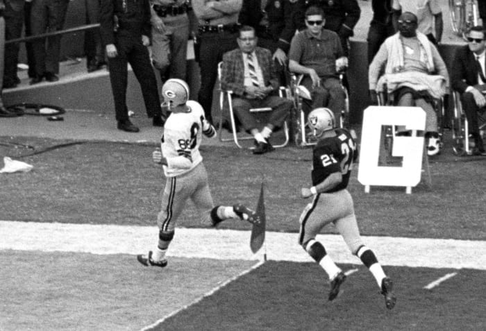 A Packers player runs past the flag at the front corner of the end zone